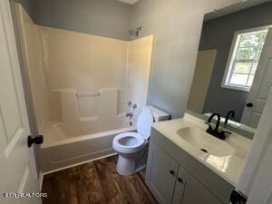 full bathroom with hardwood / wood-style floors, vanity, toilet, and bathtub / shower combination