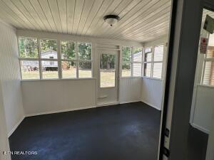 unfurnished sunroom with wood ceiling and a healthy amount of sunlight