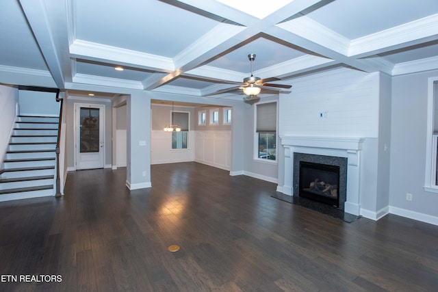 unfurnished living room featuring beam ceiling, coffered ceiling, stairway, ceiling fan, and dark wood-style flooring