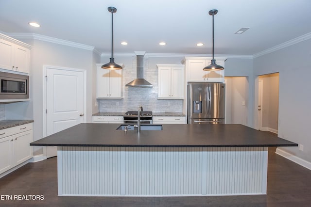 kitchen with dark countertops, appliances with stainless steel finishes, wall chimney range hood, and a sink