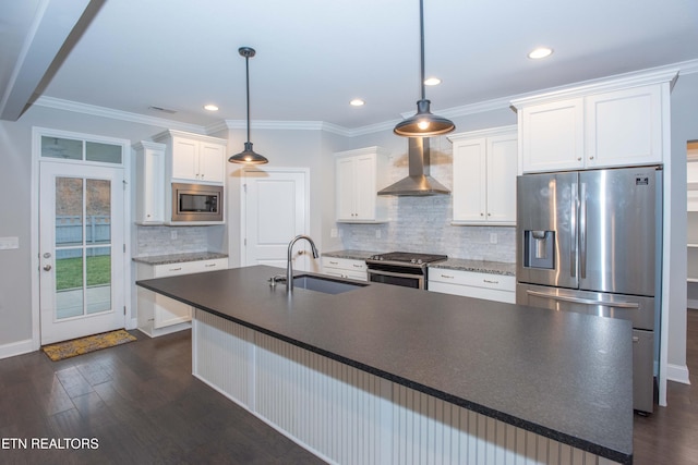 kitchen featuring a kitchen island with sink, a sink, white cabinetry, stainless steel appliances, and wall chimney exhaust hood