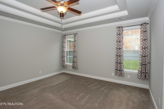 unfurnished room featuring a tray ceiling, a healthy amount of sunlight, and visible vents