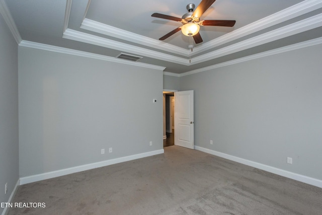 spare room with visible vents, a raised ceiling, a ceiling fan, carpet floors, and baseboards