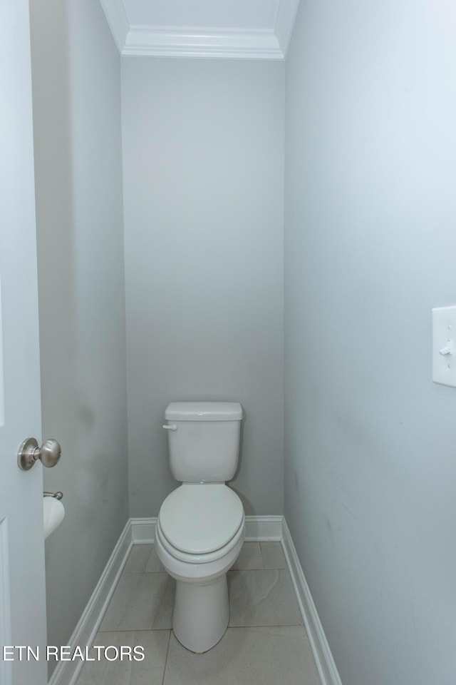 bathroom with tile patterned flooring, toilet, baseboards, and ornamental molding