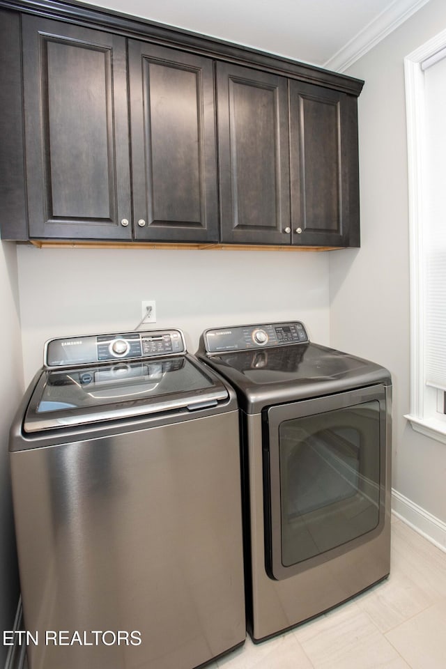 laundry area featuring cabinet space, independent washer and dryer, baseboards, and ornamental molding