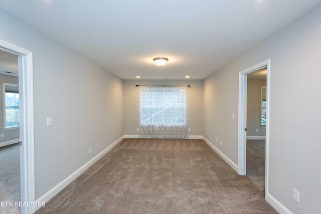 carpeted spare room with baseboards