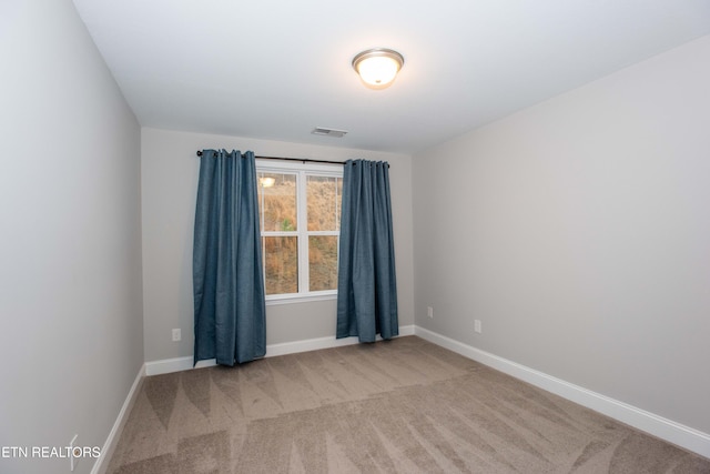 spare room with visible vents, carpet, and baseboards