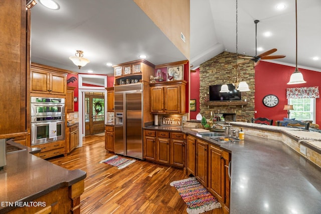 kitchen with dark hardwood / wood-style flooring, stainless steel appliances, ceiling fan, sink, and hanging light fixtures