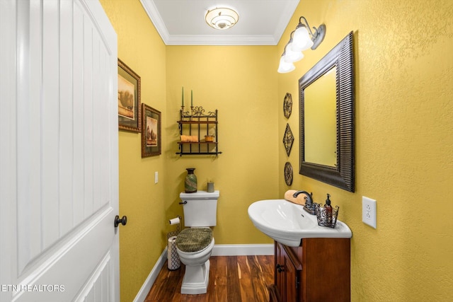 bathroom with crown molding, sink, hardwood / wood-style floors, and toilet