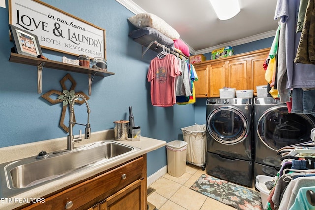 clothes washing area with sink, cabinets, independent washer and dryer, and ornamental molding