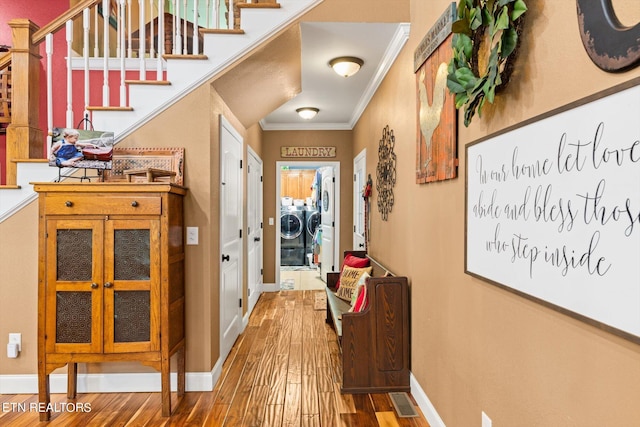 hallway with hardwood / wood-style floors, independent washer and dryer, and crown molding