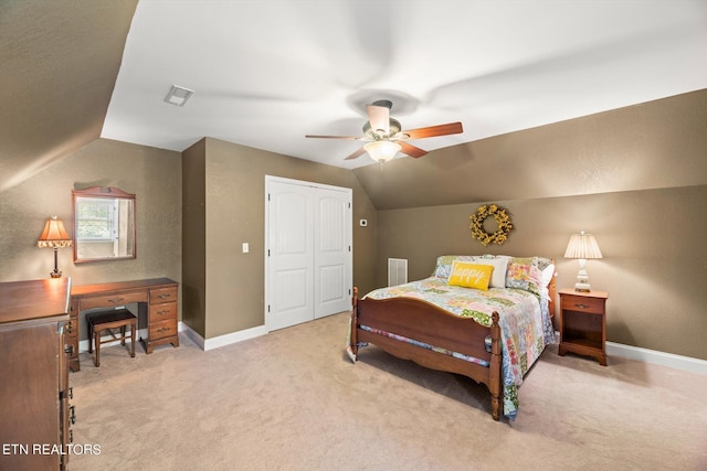 carpeted bedroom featuring ceiling fan, lofted ceiling, and a closet