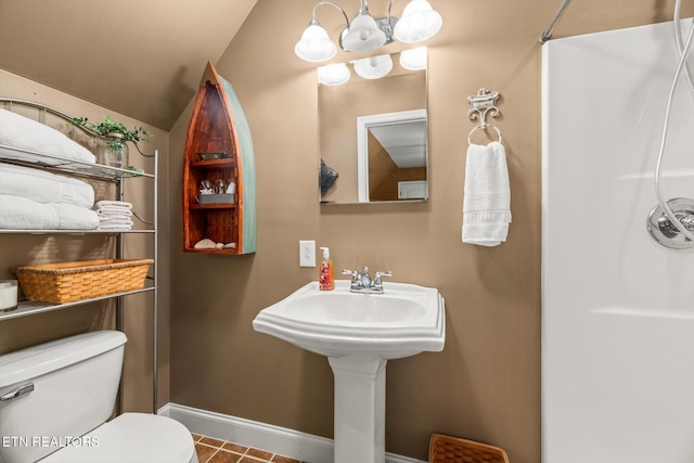 bathroom with tile patterned floors, toilet, and lofted ceiling