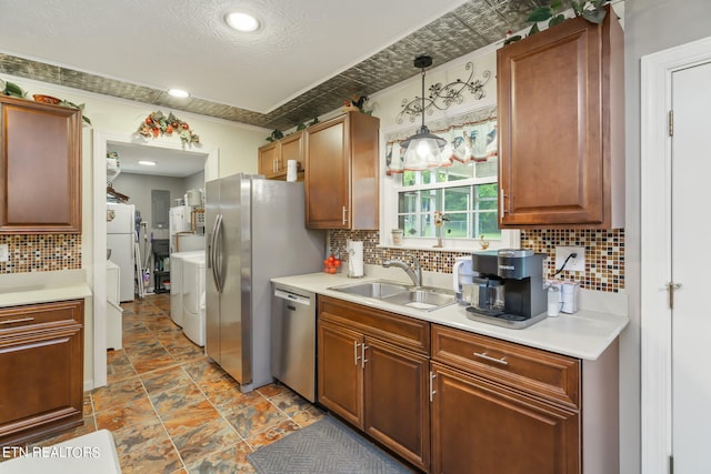 kitchen featuring decorative backsplash, sink, stainless steel appliances, and decorative light fixtures