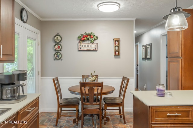 dining space with ornamental molding and a textured ceiling