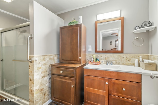 bathroom with vanity, an enclosed shower, and ornamental molding