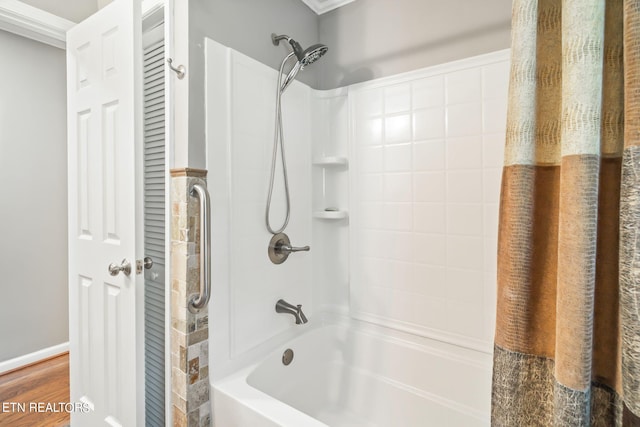 bathroom featuring hardwood / wood-style floors, shower / tub combo, and ornamental molding