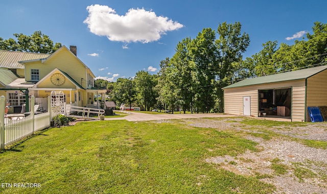 view of yard featuring an outbuilding, a garage, and covered porch