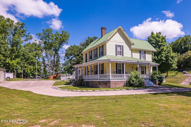 farmhouse inspired home with a porch and a front yard