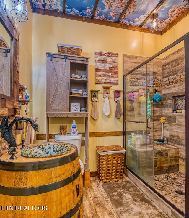 bathroom with hardwood / wood-style flooring and walk in shower