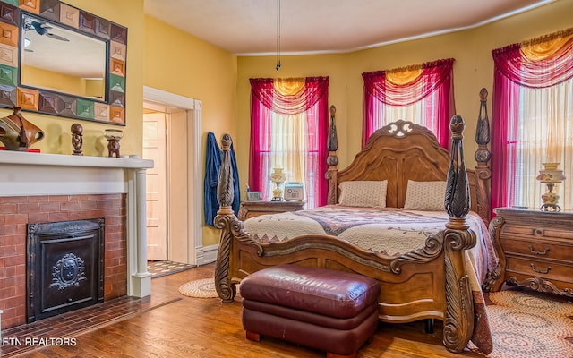 bedroom with a fireplace and wood-type flooring