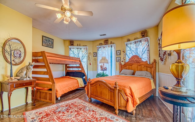 bedroom with multiple windows, ceiling fan, and hardwood / wood-style flooring