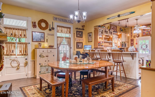 dining room featuring hardwood / wood-style floors and ceiling fan with notable chandelier