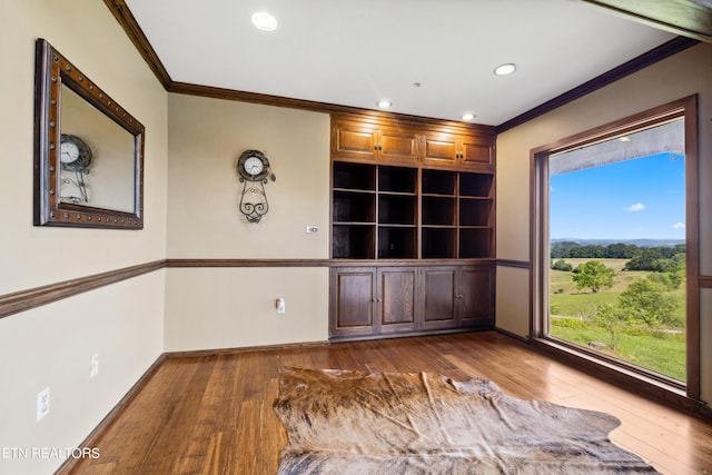 spare room with crown molding and dark wood-type flooring