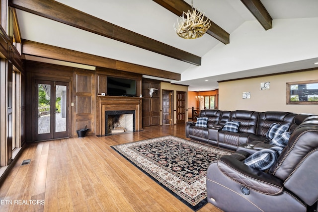 living room with beamed ceiling, light hardwood / wood-style flooring, high vaulted ceiling, and french doors