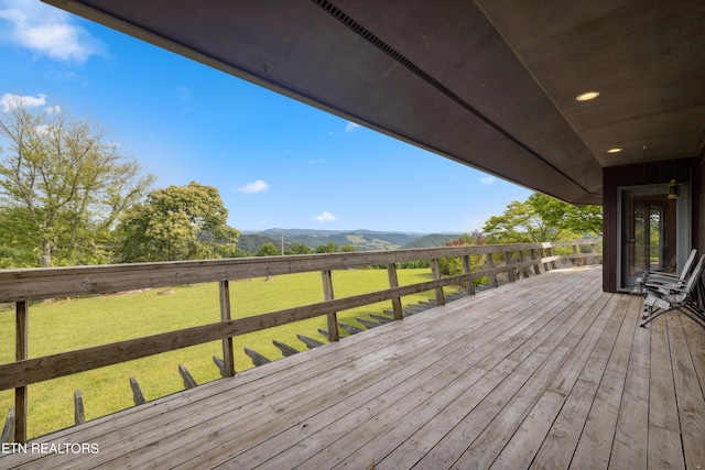 wooden terrace with a mountain view and a yard