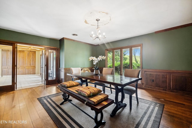 dining space with a chandelier, dark hardwood / wood-style flooring, and ornamental molding