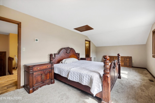 bedroom with light colored carpet and vaulted ceiling