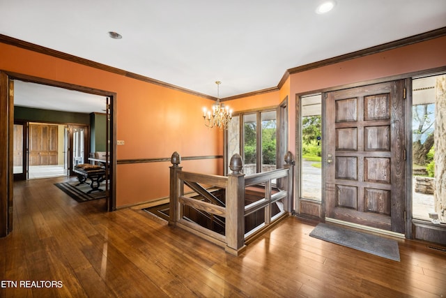 entryway featuring a chandelier, wood-type flooring, and ornamental molding