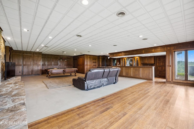 unfurnished living room featuring wooden walls, billiards, and light wood-type flooring