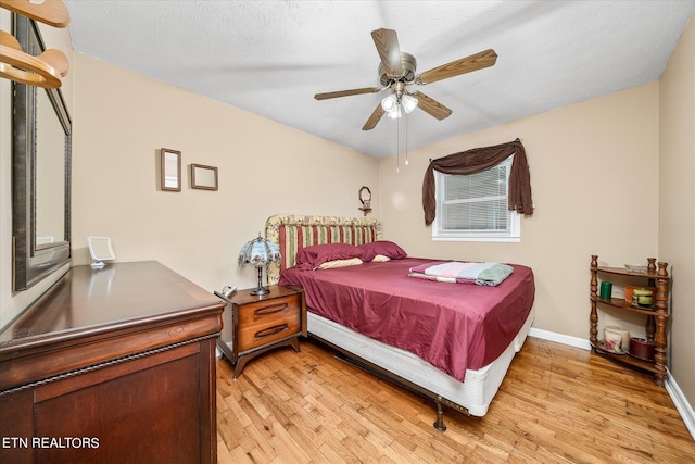 bedroom with ceiling fan, a textured ceiling, and light hardwood / wood-style floors