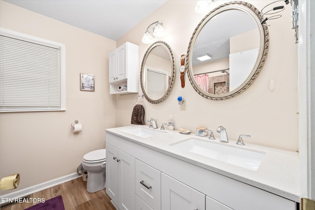 bathroom featuring toilet, vanity, and hardwood / wood-style floors