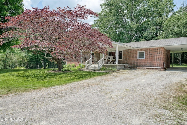 view of front of house featuring a front lawn, a porch, and a carport