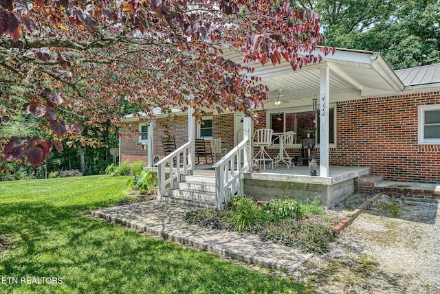 rear view of house with a lawn and covered porch