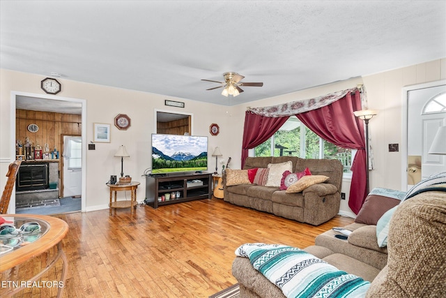 living room with hardwood / wood-style flooring, a textured ceiling, and ceiling fan