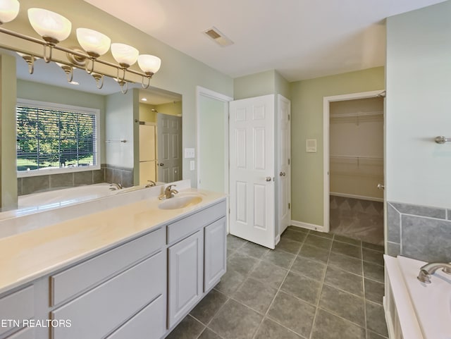 bathroom featuring vanity, a tub, and tile patterned flooring