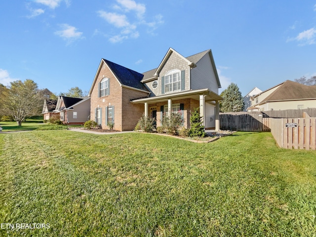 rear view of property with a yard and covered porch