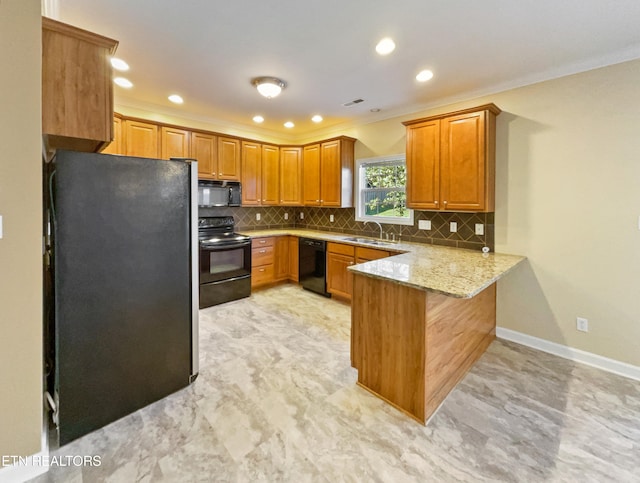 kitchen featuring kitchen peninsula, tasteful backsplash, light stone counters, black appliances, and sink