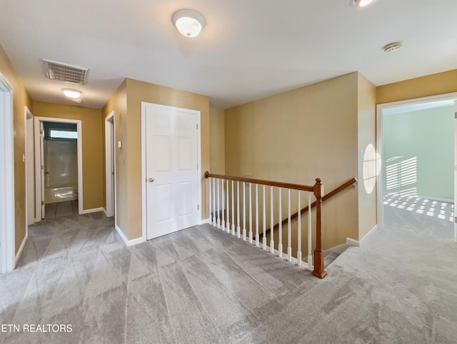 corridor featuring light colored carpet