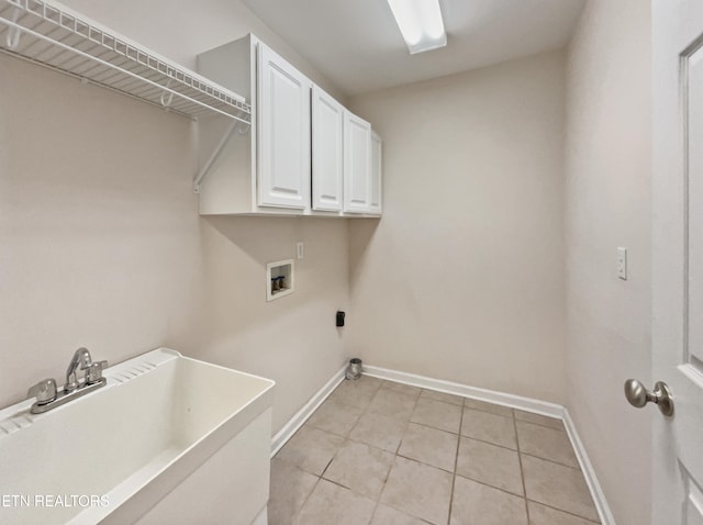 clothes washing area featuring light tile patterned flooring, hookup for a washing machine, sink, and cabinets