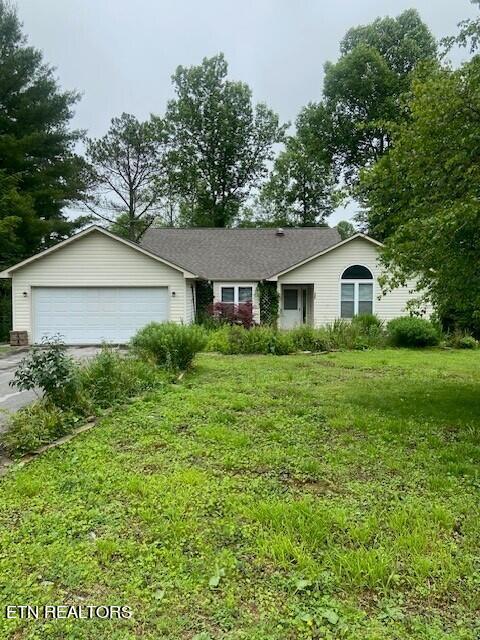 single story home with a front yard and a garage