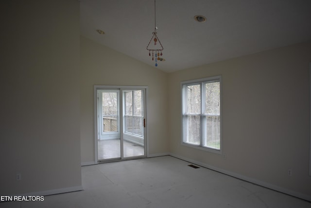 spare room featuring baseboards, vaulted ceiling, and visible vents