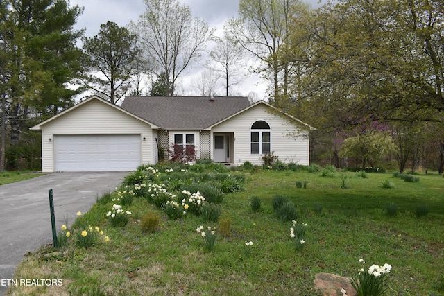 ranch-style home featuring a shingled roof, a garage, and aphalt driveway