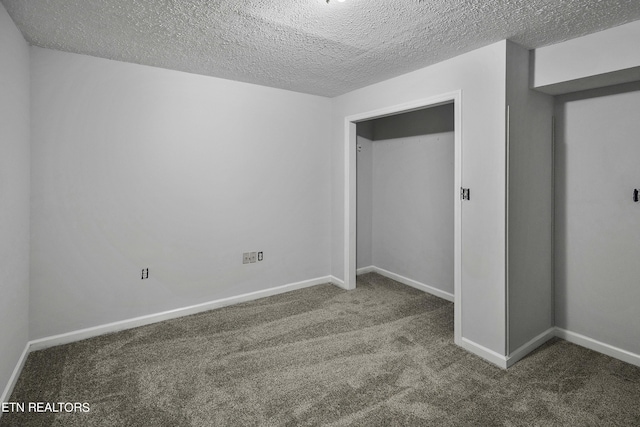 unfurnished bedroom featuring a textured ceiling and dark colored carpet