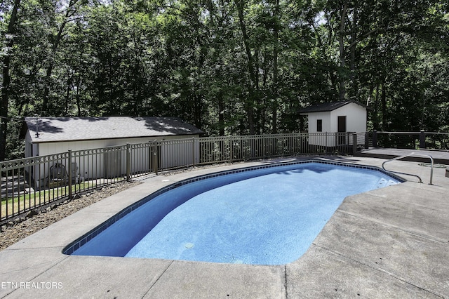 view of swimming pool with a patio area and a storage shed