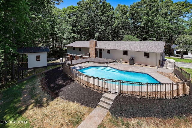 view of swimming pool featuring central AC unit and a shed